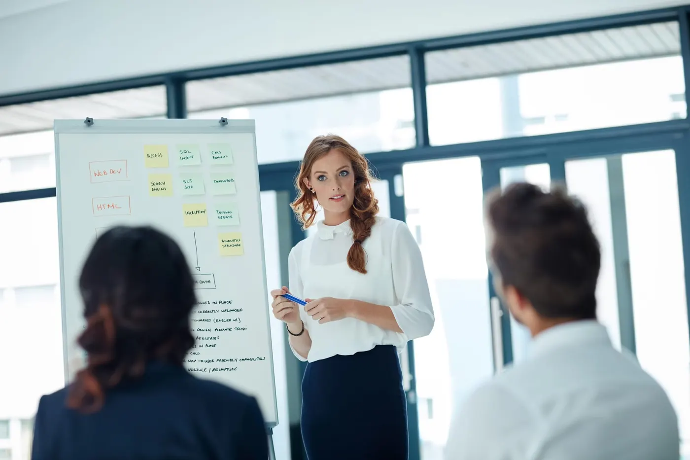 Réunion de restitution autour d'une table, avec un tableau de bord projeté
