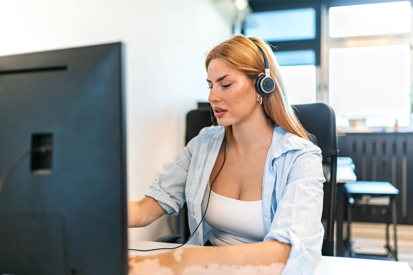 Conseillère support client travaillant avec un agent IA sur son écran