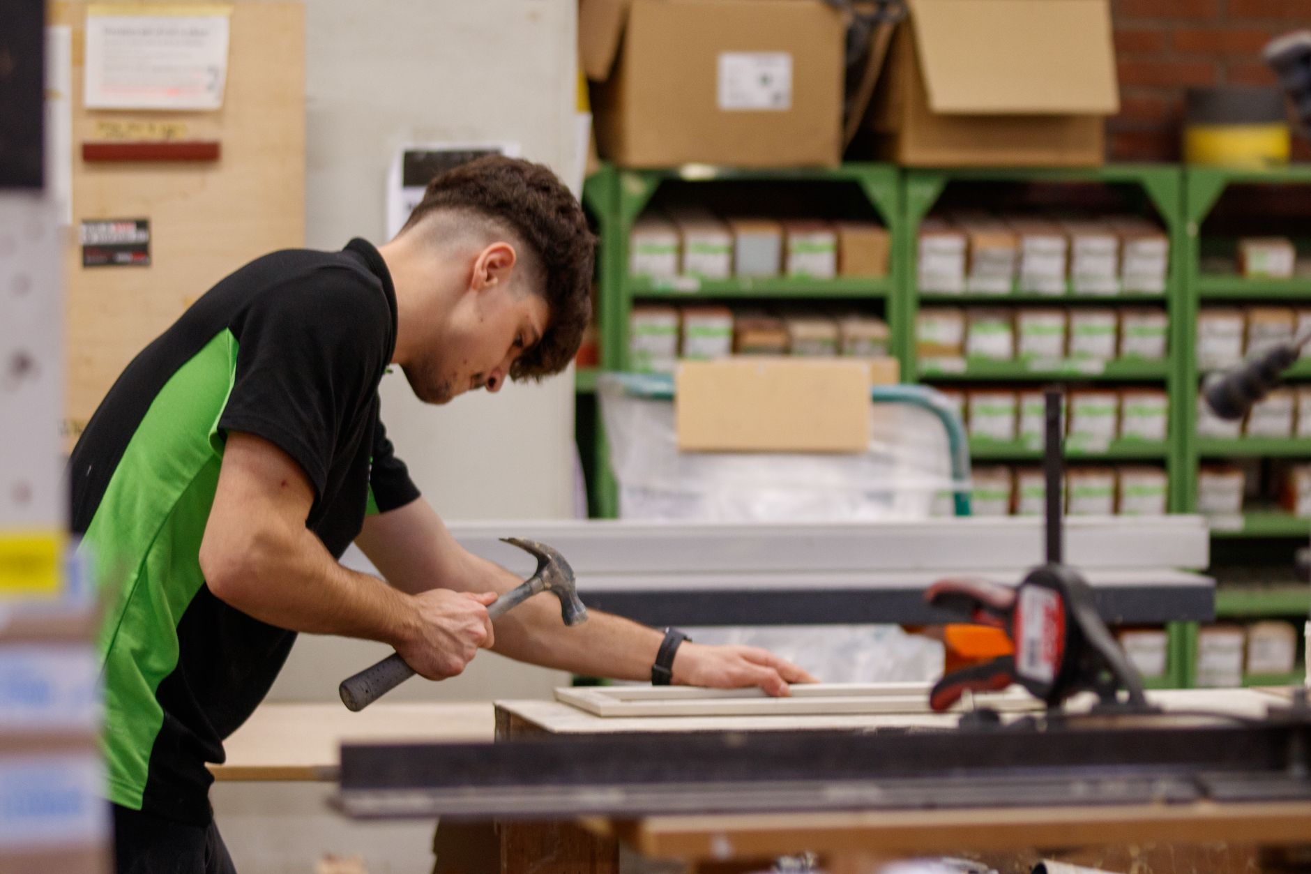 Artisan assemblant des modules pré-fabriqués dans un atelier.