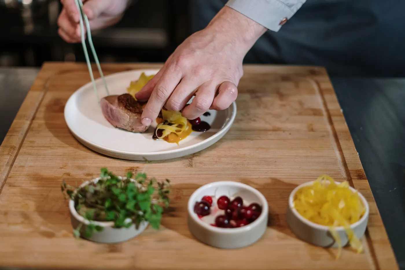 Chef cuisinier préparant un plat avec des ingrédients de précision.