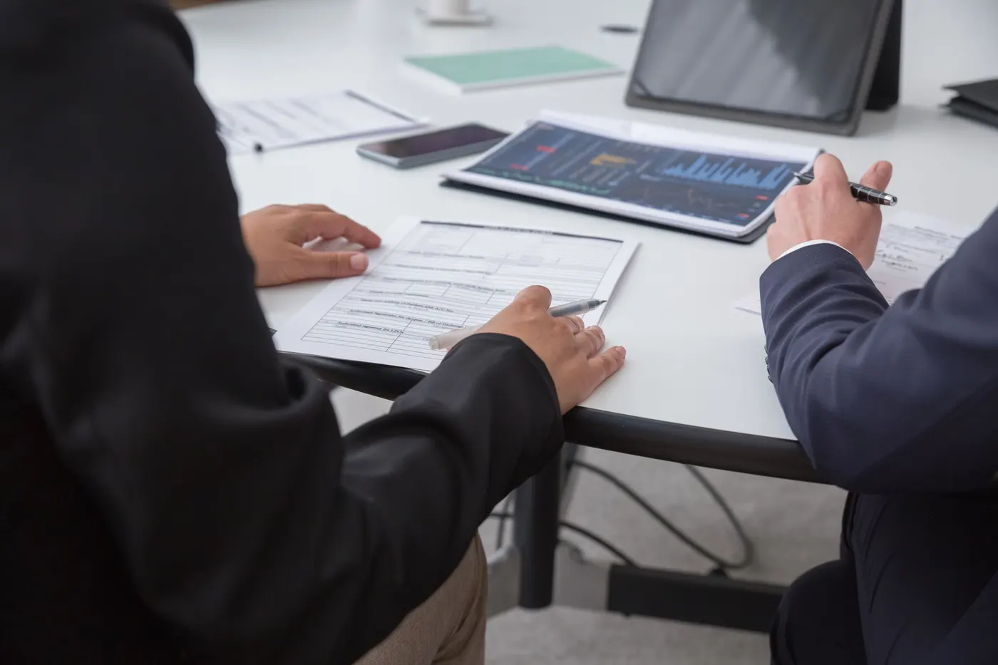 Experts en bureau parisien identifiant une erreur critique sur un plan.