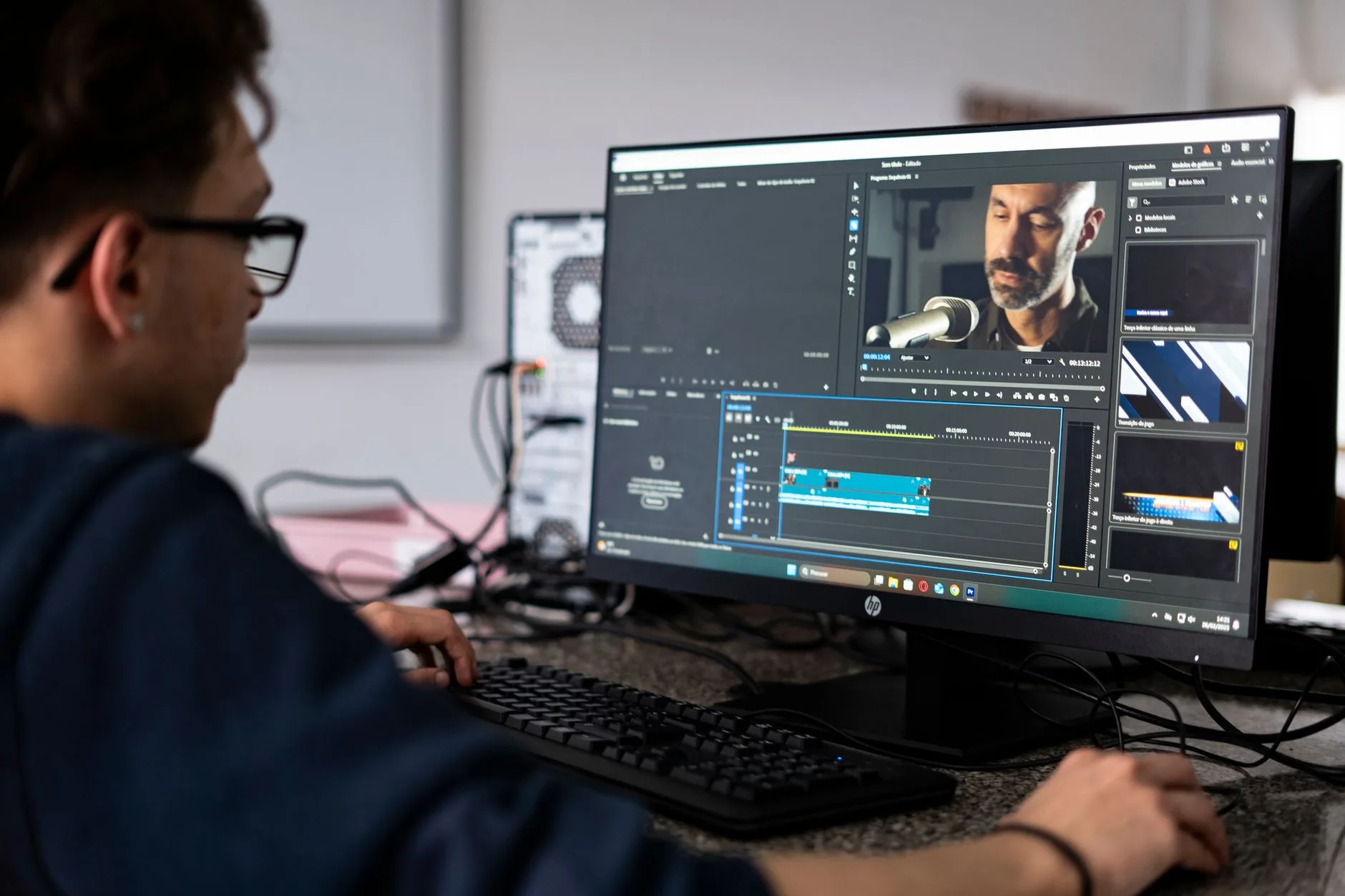 Monteur vidéo assemble une séquence sur un logiciel de montage devant deux écrans au bureau