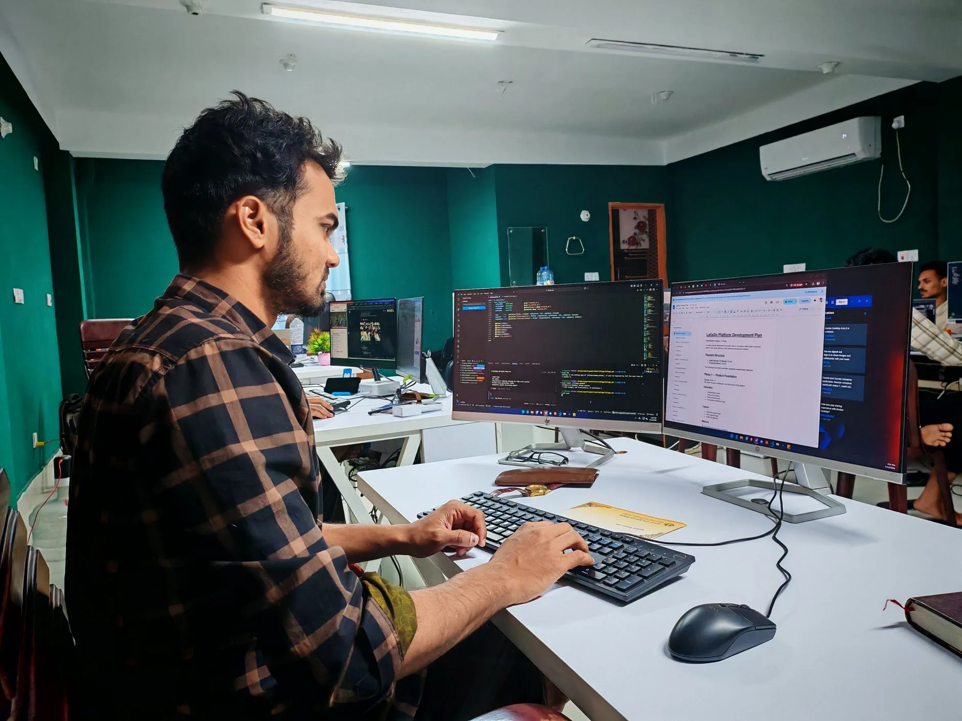 Développeur concentré devant deux écrans affichant du code dans un bureau