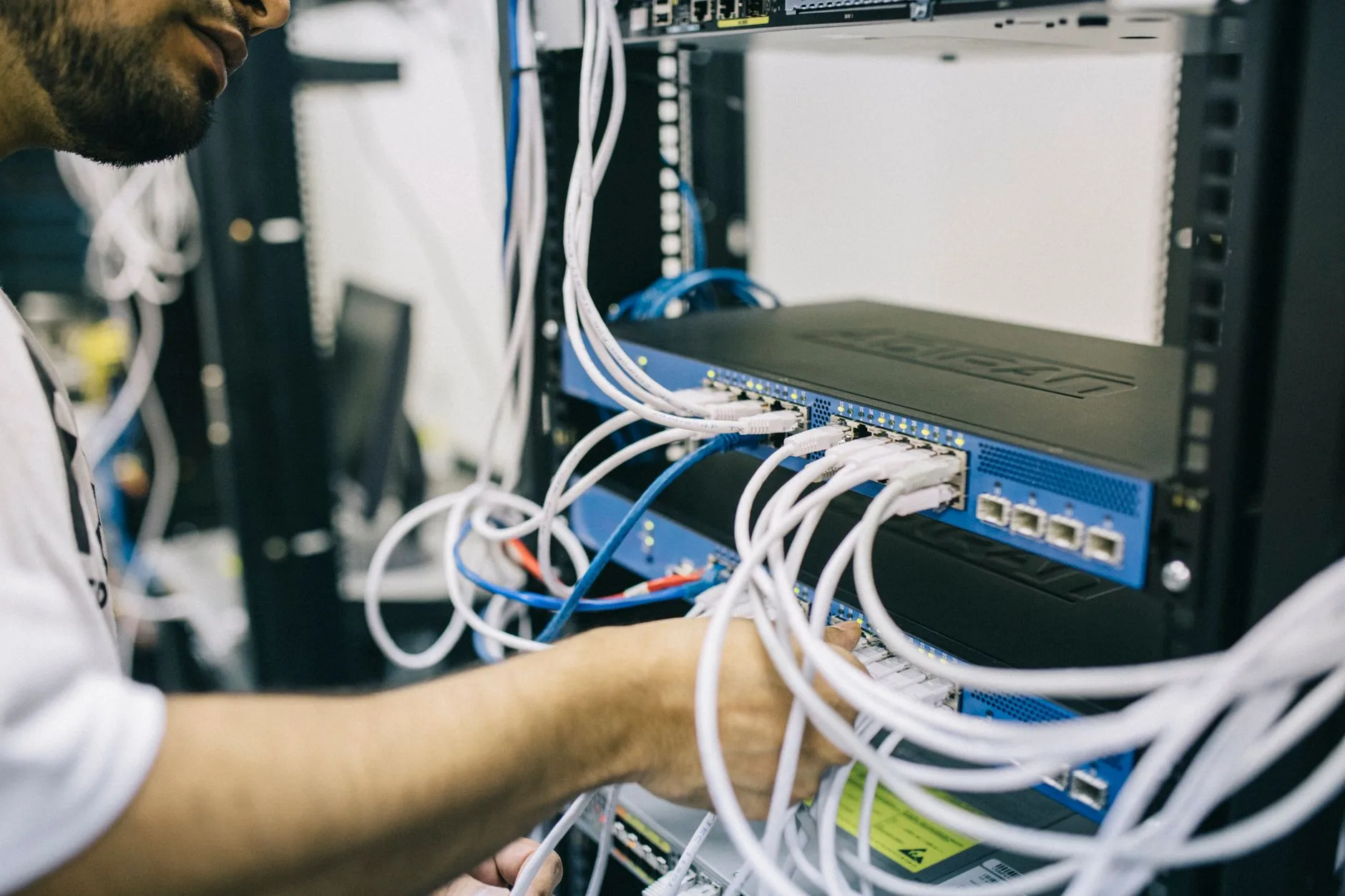 Technicien réseau branche des câbles Ethernet sur une baie de serveurs