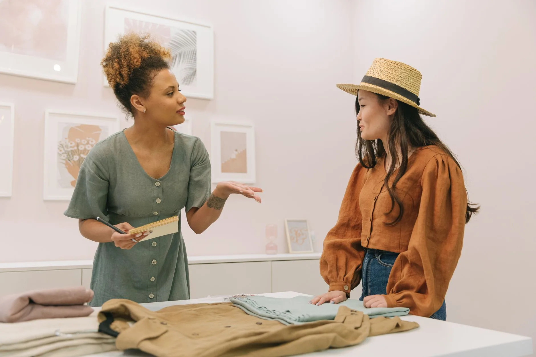 Deux créatrices de mode échangent autour d’un vêtement posé sur un buste dans leur atelier