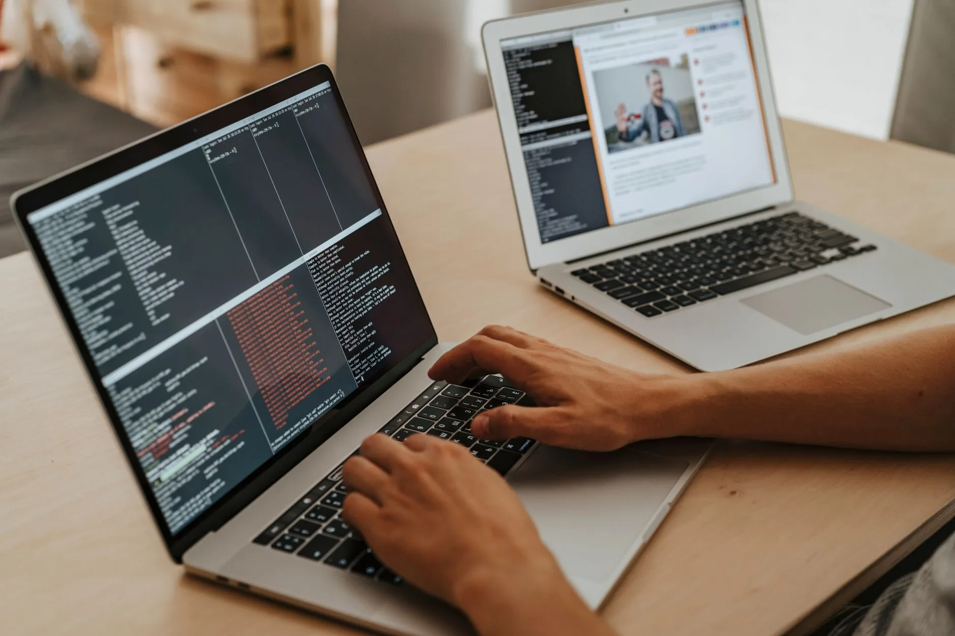 Développeur testant un connecteur sur deux ordinateurs portables posés sur un bureau en bois