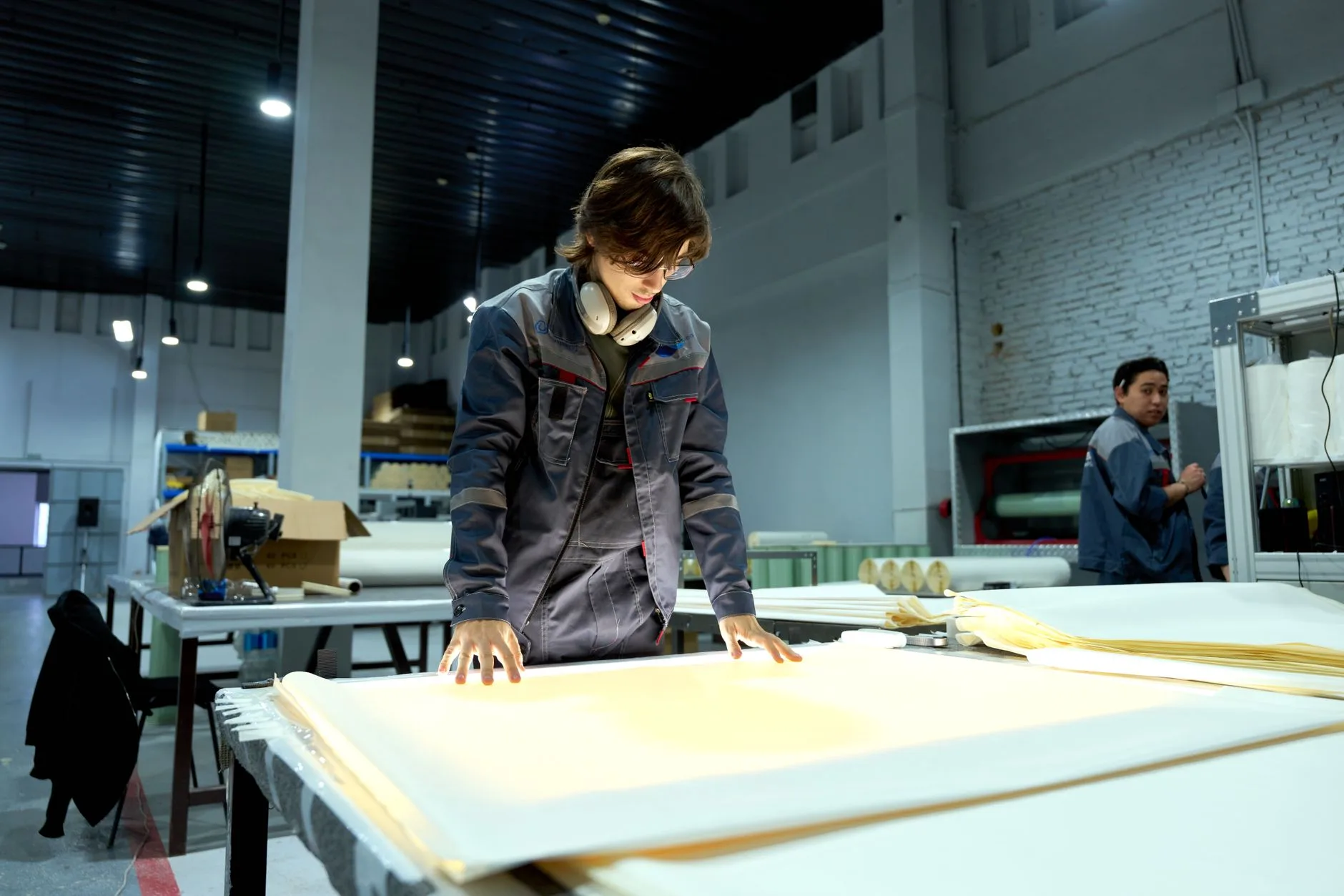 Opérateur en atelier de production contrôlant des panneaux sur un poste de découpe