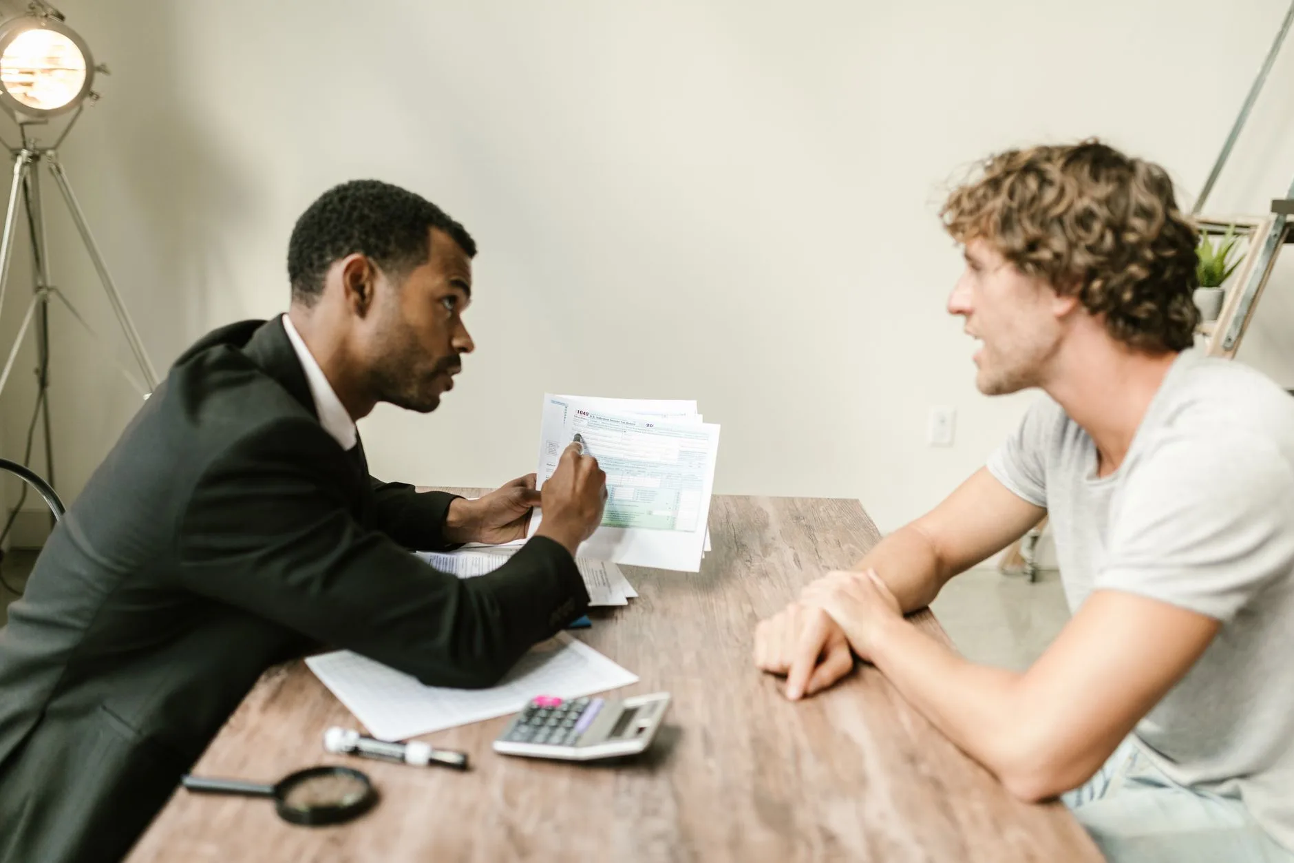 Conseiller bancaire présente un dossier de souscription à un jeune client lors du rendez-vous d'ouverture
