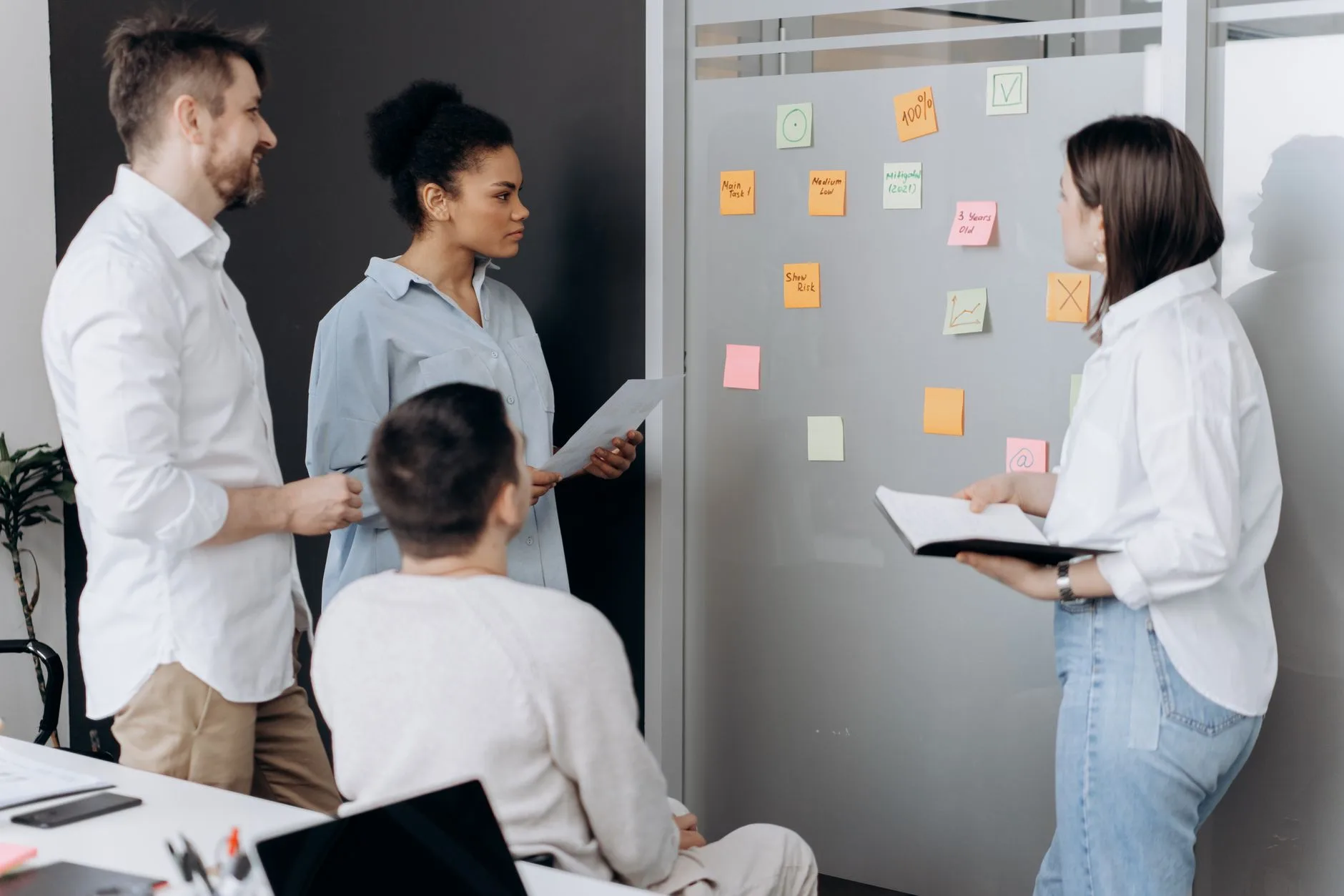 Équipe réunie devant un mur de post-it pour prioriser les corrections à mener
