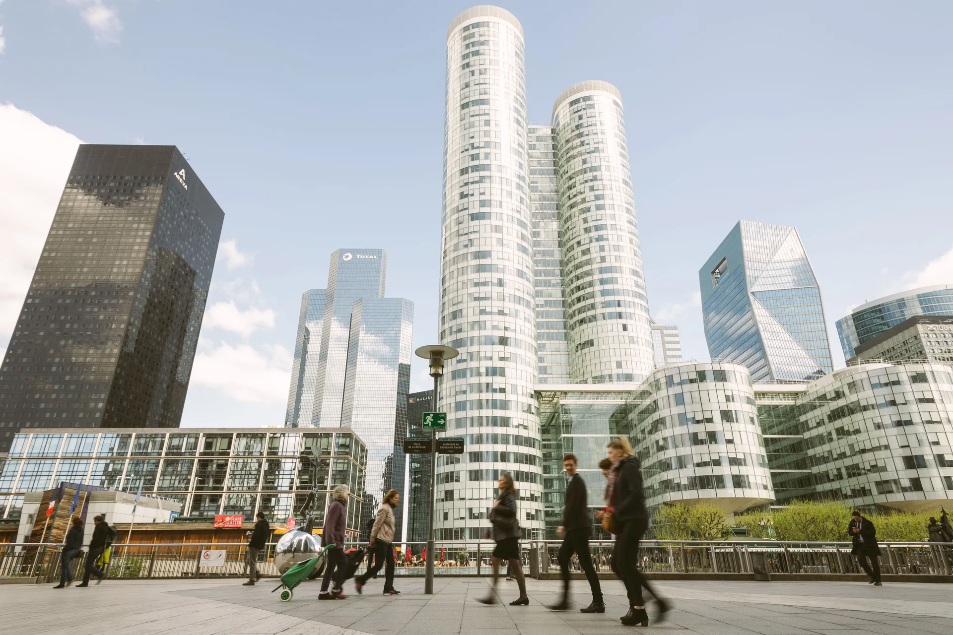 Passants marchant au pied des tours de La Défense à Paris