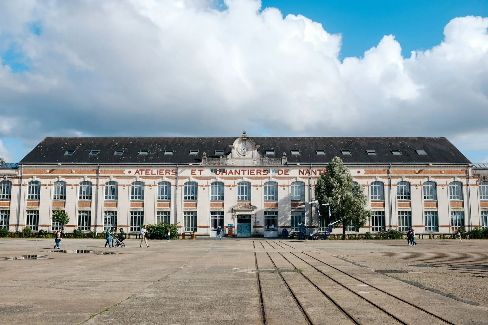Façade des anciens Ateliers et Chantiers de Nantes sur l'île de Nantes, rails au premier plan