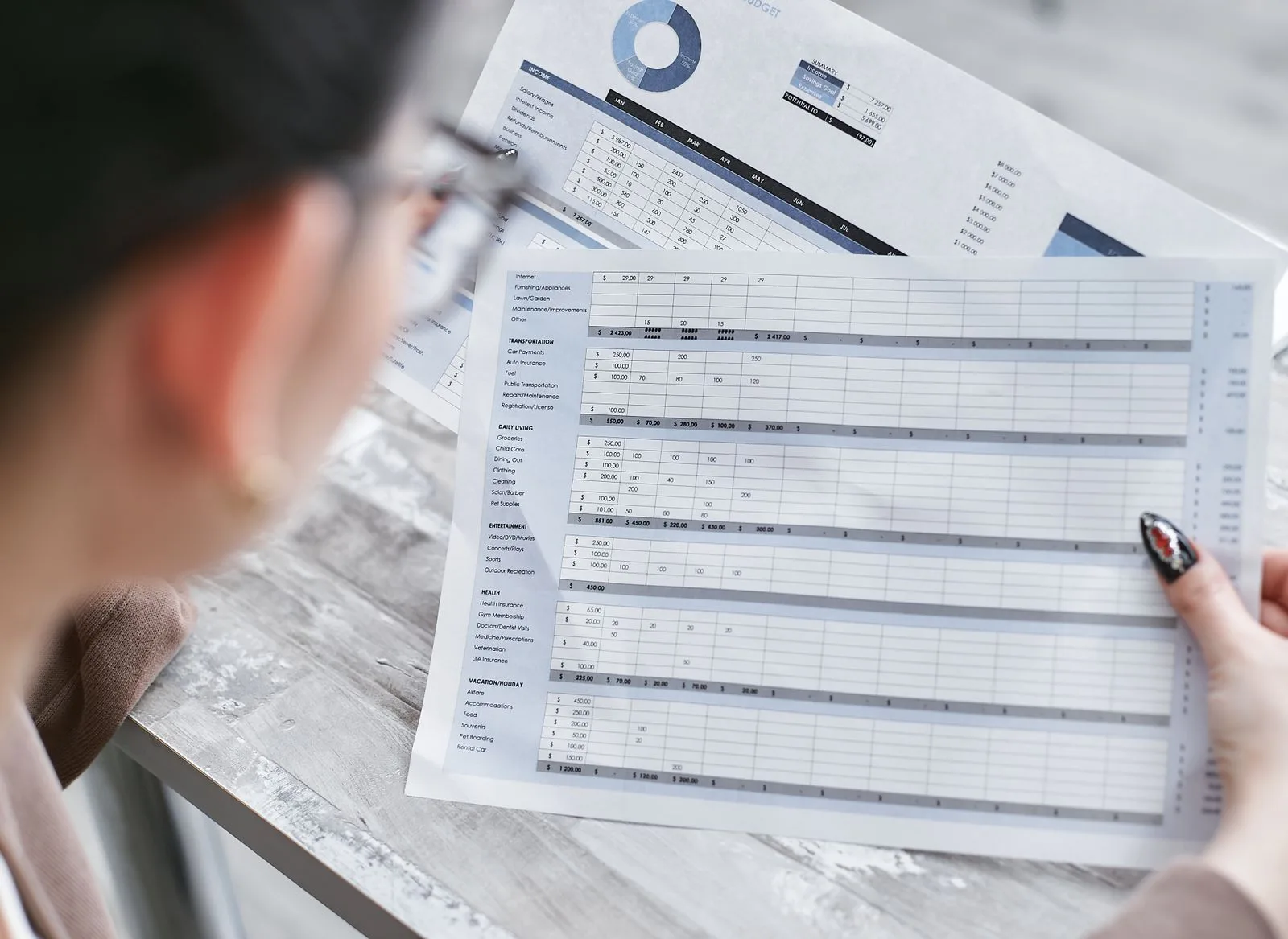 Une contrôleuse de gestion relit une feuille de calcul imprimée dans un bureau