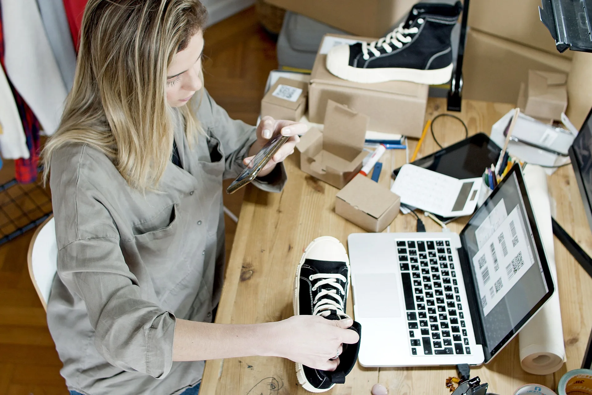 Commerçante photographiant une chaussure pour sa fiche produit en ligne