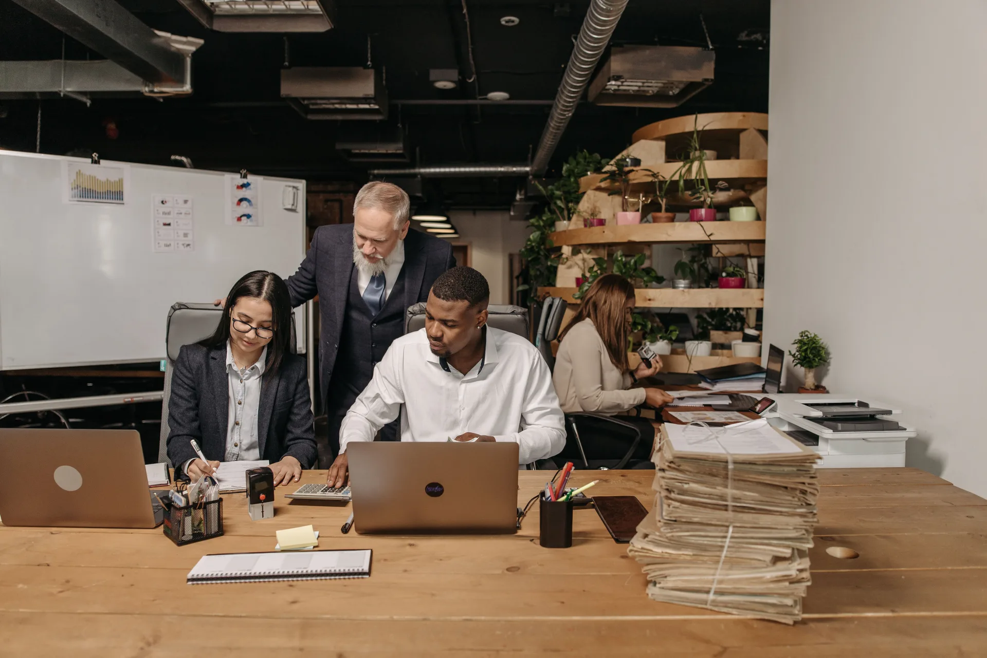 Équipe technique collaborant autour d'ordinateurs portables dans un bureau moderne